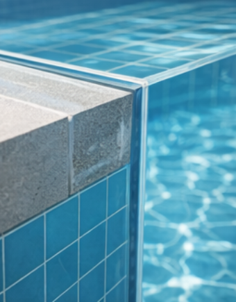 Tile to acrylic interface at pool edge showing material transition